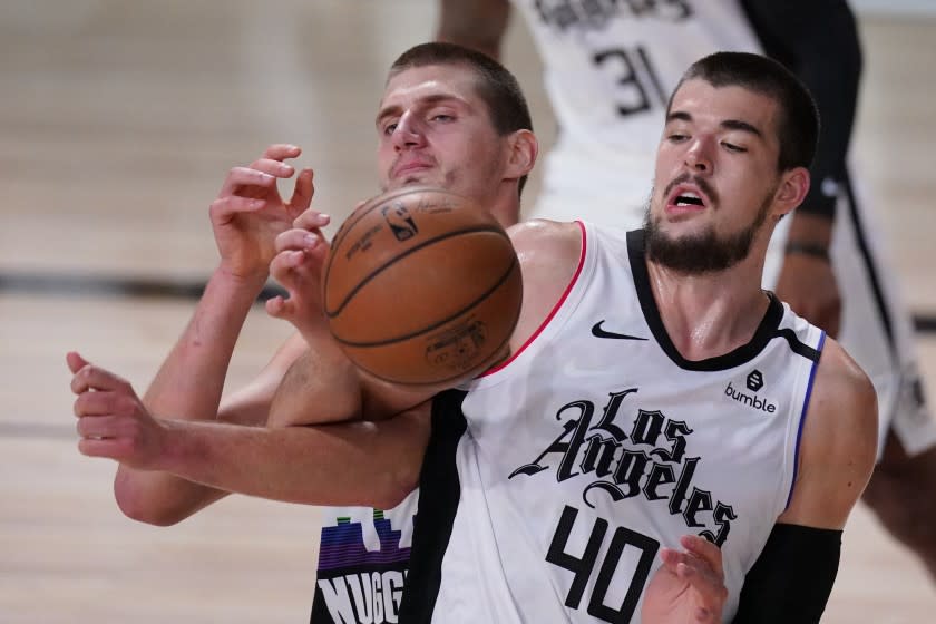 Denver Nuggets' Nikola Jokic, left, and Los Angeles Clippers' Ivica Zubac (40) battle for a rebound.