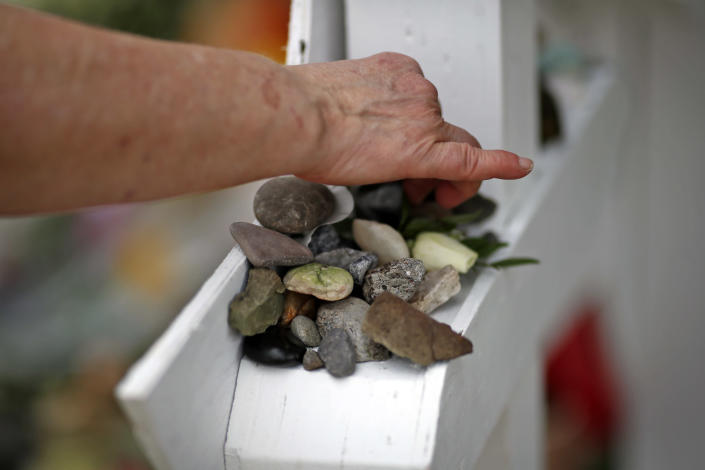 <p>Geri Melnick, of Pittsburgh, places a stone on a memorial to Irv Younger during a visit to a makeshift memorial Wednesday, Oct. 31, 2018, outside the Tree of Life Synagogue, to the 11 people killed during worship services Saturday in Pittsburgh. (Photo: Gene J. Puskar/AP) </p>
