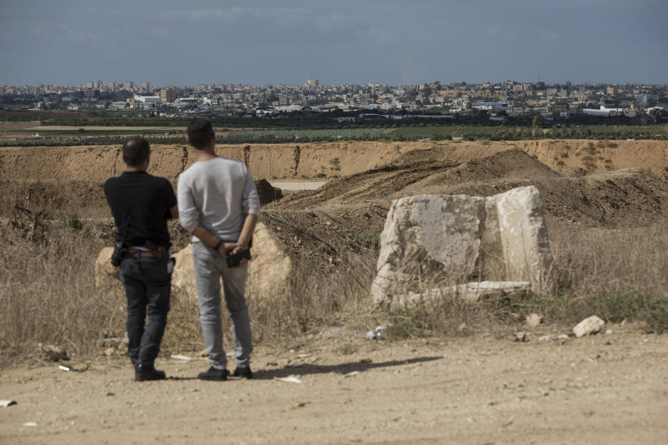 Israelis look at the Gaza Strip border, Saturday, Oct. 27, 2018. The Israeli military has struck dozens of targets across the Gaza Strip in response to heavy rocket fire and threatened to expand its air campaign to Syria after accusing Iranian forces in Damascus of orchestrating the rocket attacks. (AP Photo/Tsafrir Abayov)