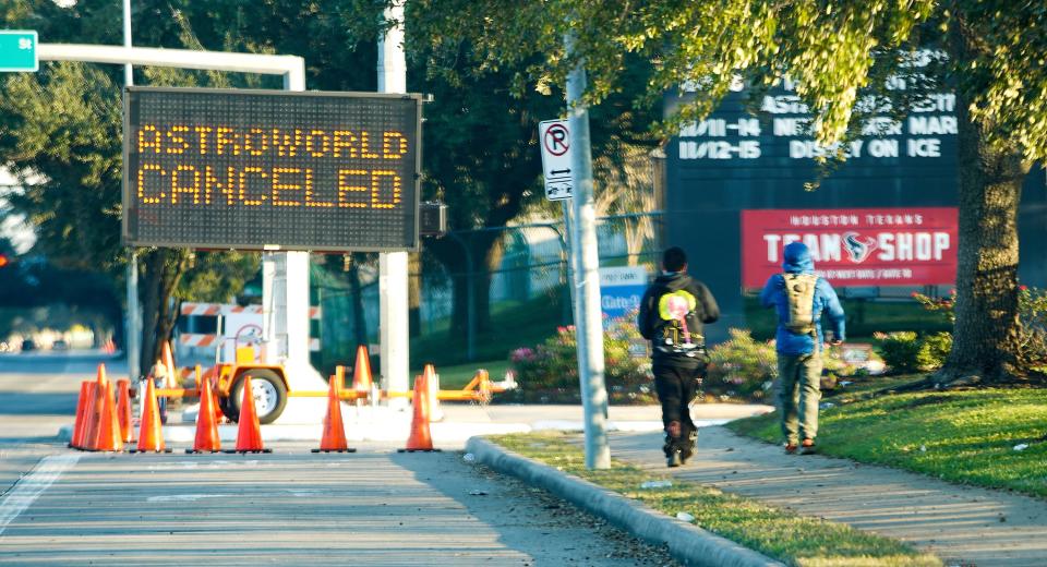 People walk past a sign announcing Astroworld's cancellation in Houston on Nov. 6, 2021. The 10 people who lost their lives in a massive crowd surge at the music festival died from compression asphyxia, according to officials.