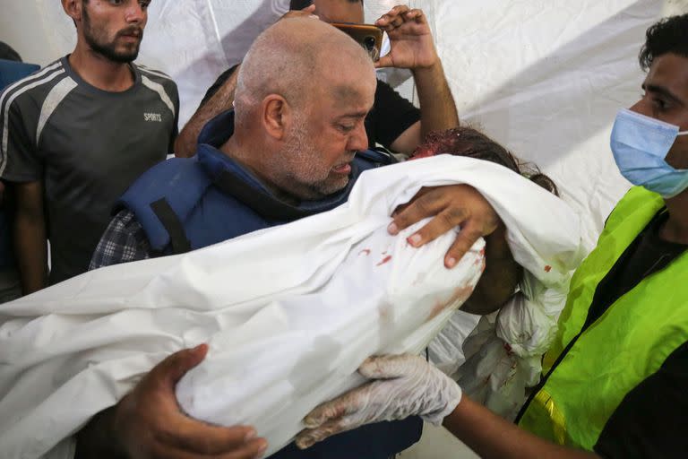 El corresponsal de Al-Jazeera en Gaza Wael Al-Dahdouh con el cuerpo de uno de sus hijos muertos en el bombardeo sobre el campo de refugiados de Nuseirat, en Gaza. (Majdi FATHI / AFP)