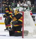 Dallas Stars' Jason Robertson, Miro Heiskanen (4), Jamie Benn (14), Roope Hintz (24) and Joe Pavelski (16) celebrate Hintz's goal as Vancouver Canucks' Ian Cole (82) and goalie Casey DeSmith (29) react during the first period of an NHL hockey game Thursday, March 28, 2024, in Vancouver, British Columbia. (Darryl Dyck/The Canadian Press via AP)