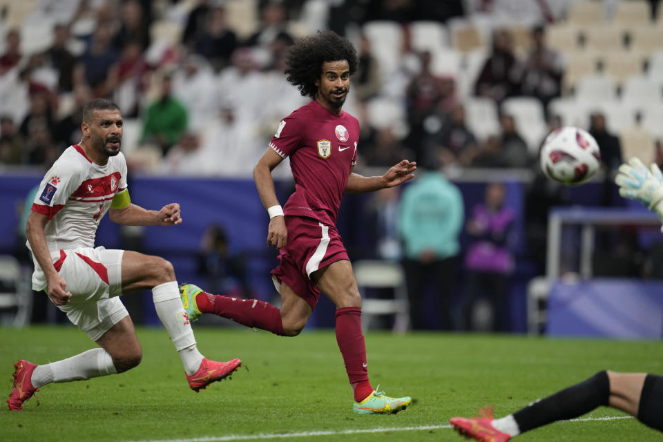 Qatar's Akram Afif, right, scores his side's third goal during the Asian Cup Group A soccer match between Qatar and Lebanon at the Lusail Stadium in Lusail, Qatar, Friday, Jan. 12, 2024. (AP Photo/Aijaz Rahi)