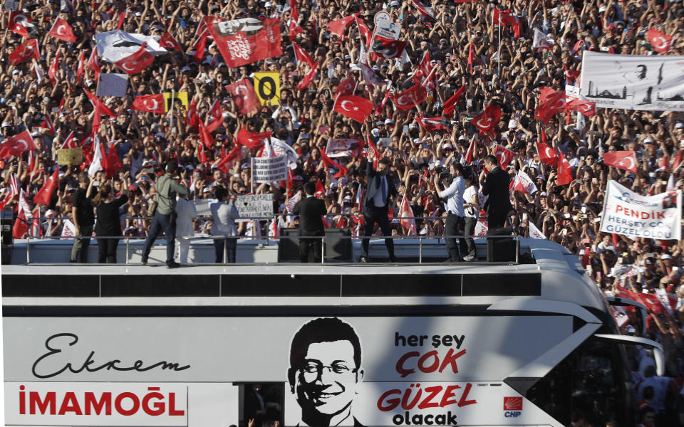 Thousands of supporters surround a bus from where Ekrem Imamoglu, the new Mayor of Istanbul from Turkey's main opposition opposition Republican People's Party (CHP) makes a speech after he took over office, in Istanbul, Thursday, June 27, 2019. Imamoglu is formally taking office as mayor of Istanbul four days after he won a repeat election in Turkey's largest city and commercial hub. (AP Photo/Lefteris Pitarakis)