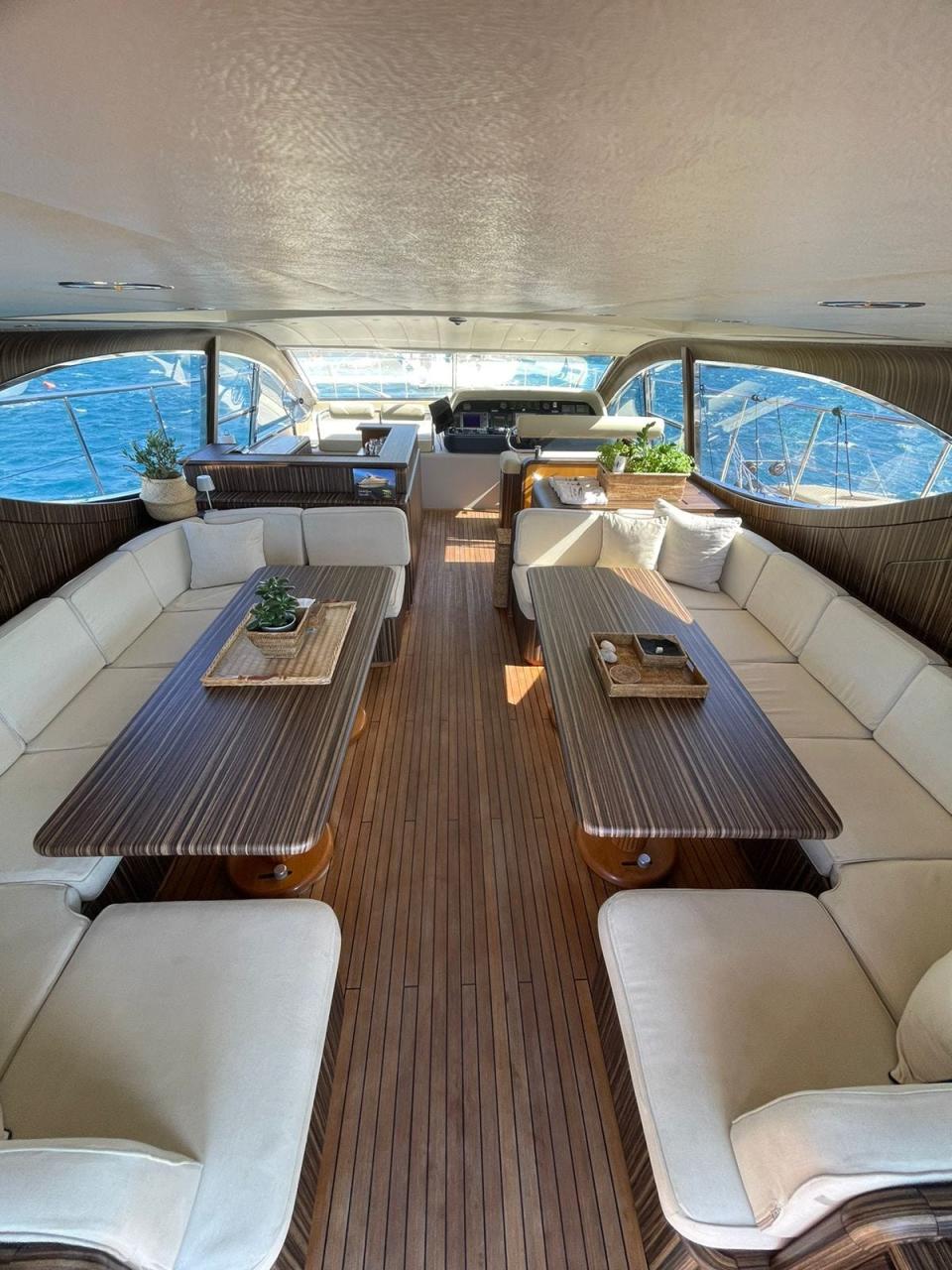 Interior view of Zeus yacht with two dining tables and two booths