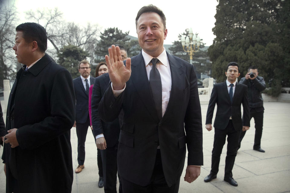 Tesla CEO Elon Musk, center, waves as he waits for a meeting with Chinese Premier Li Keqiang at the Zhongnanhai leadership compound in Beijing, Wednesday, Jan. 9, 2019. (AP Photo/Mark Schiefelbein, Pool)