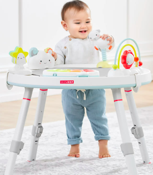 A baby standing at the activity center