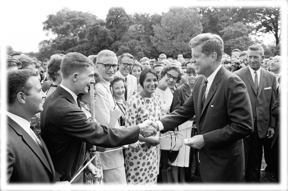 President John F. Kennedy during a 1962 White House lawn ceremony for Peace Corps trainees preparing to take up their posts. (Photo: Bettmann Archive via Getty Images; digitally enhanced by Yahoo News)