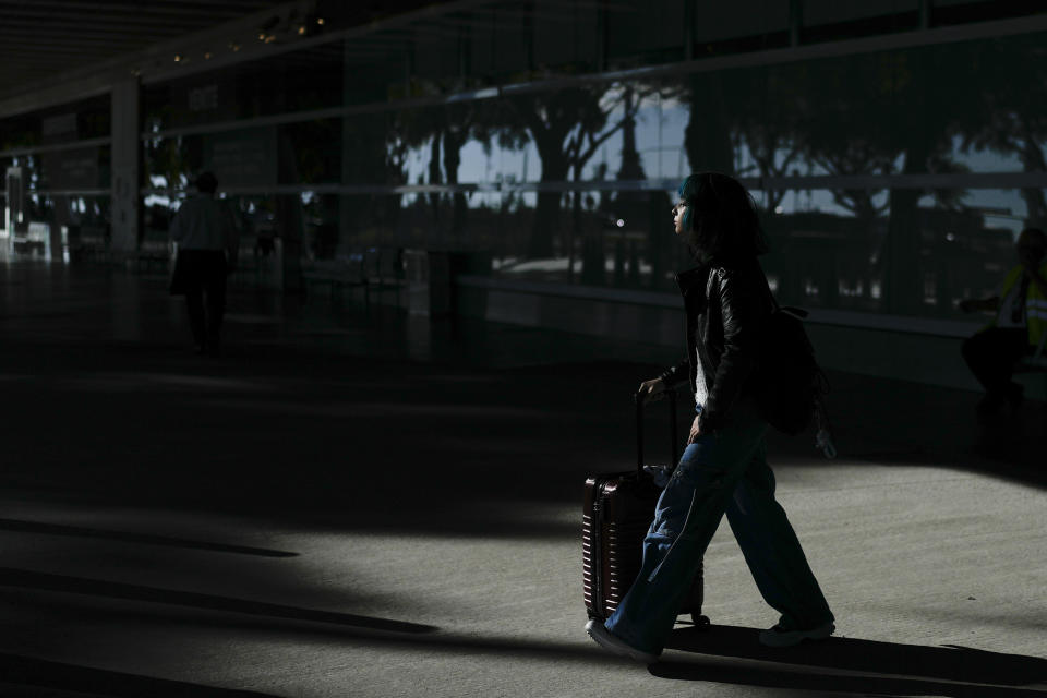 A tourist from Chile walks outside the Jorge Newbery airport after her flight was suspended in Buenos Aires, Argentina, Wednesday, Feb. 28, 2024. Airport and airline workers, as well as pilots, are staging a 24-hour strike for improved wages. (AP Photo/Natacha Pisarenko)