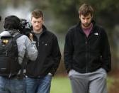 An unidentified Al Jazeera cameraman watches Northwestern football players Chris Gradone and Zach Oliver, right, as they walk to McGaw Hall where voting is taking place on the student athlete union question Friday, April 25, 2014, in Evanston, Ill. Northwestern football players cast secret ballots Friday in an on-campus hall adjacent to their home stadium on whether to form the nation's first union for college athletes. (AP Photo/Charles Rex Arbogast)