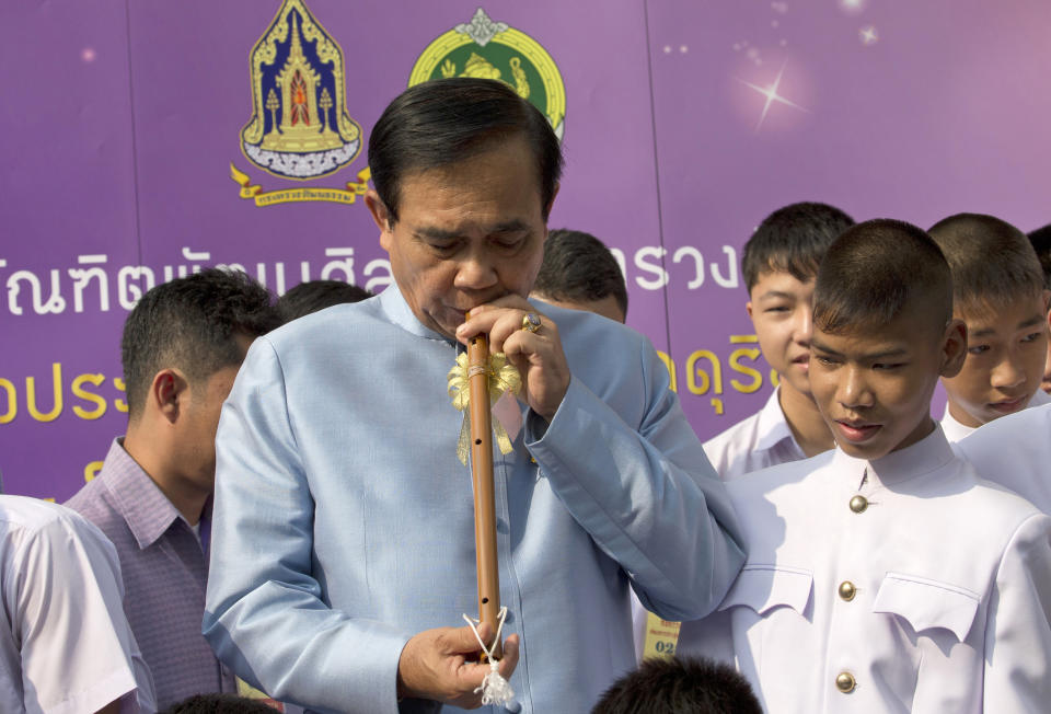 Thai Prime Minister Prayuth Chan-ocha blows flute during an event to promote Thai Heritage Conservation Day before cabinet meeting at the government house in Bangkok, Thailand, Tuesday, March 26, 2019. The junta-appointed Election Commission announced the results of 350 constituency races but said full vote counts, which are needed to allocate 150 other seats in the House of Representatives, won't be available until Friday after apparent counting problems. (AP Photo/Sakchai Lalit)