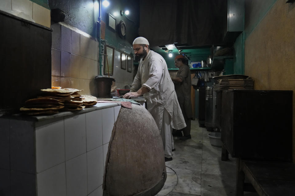 Bilal Sufi, owner of Baking Virsa eatery, prepares kebabs in Lahore, Pakistan, Saturday, Dec. 3, 2022. No menu. Baking Virsa, a hole-in-the-wall in the eastern Pakistani city of Lahore described as the country's most expensive restaurant for serving household favorites like flatbreads and kebabs at exorbitant prices. (AP Photo/K. M. Chaudary)