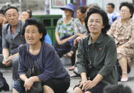 <p>North Koreans watch a report of North Korean leader Kim Jong Un’s late-night tour of Singapore, near a station in Pyongyang on Tuesday. (Photo: Minoru Iwasaki/Kyodo News via AP) </p>