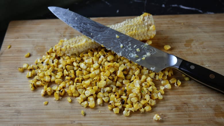 cutting board with corn kernels and cob