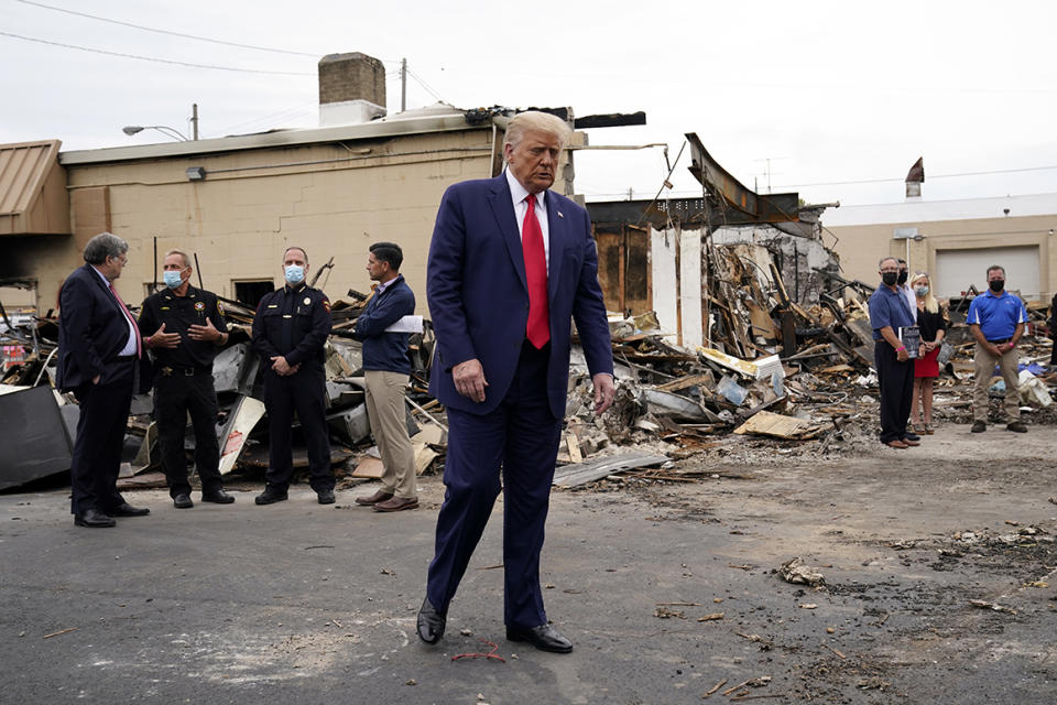 President Donald Trump tours an area on Tuesday damaged during demonstrations after a police officer shot Jacob Blake in Kenosha, Wis.