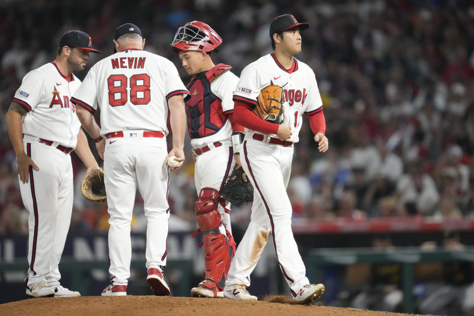 Los Angeles Angels starting pitcher Shohei Ohtani (17) is pulled from the mound by manager Phil Nevin (88) during the seventh inning of a baseball game against the Pittsburgh Pirates in Anaheim, Calif., Friday, July 21, 2023. (AP Photo/Ashley Landis)