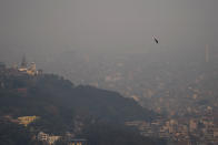 A bird is seen flying as smog envelops the skyline in Kathmandu, Nepal, May 3, 2024. Pollution from buses and other vehicles and from burning fuels for cooking and heating made Kathmandu one of the world's worst polluted cities for several days in April, as the government warned people to stay indoors. (AP Photo/Niranjan Shrestha)