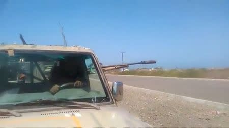 Members of UAE-backed fighters, Yemeni Resistance Giants' Brigade fire the gun from the back of truck, near airport on the outskirts of Hodeidah, Yemen, June 19, 2018 in this still image taken from video. YEMENI RESISTANCE GIANTS' BRIGADE/REUTERS