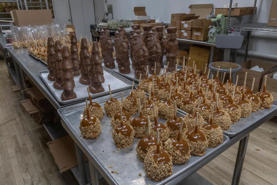 A working area at Criterion Chocolates in Eatontown, showing chocolates and caramel apples coated in nuts.