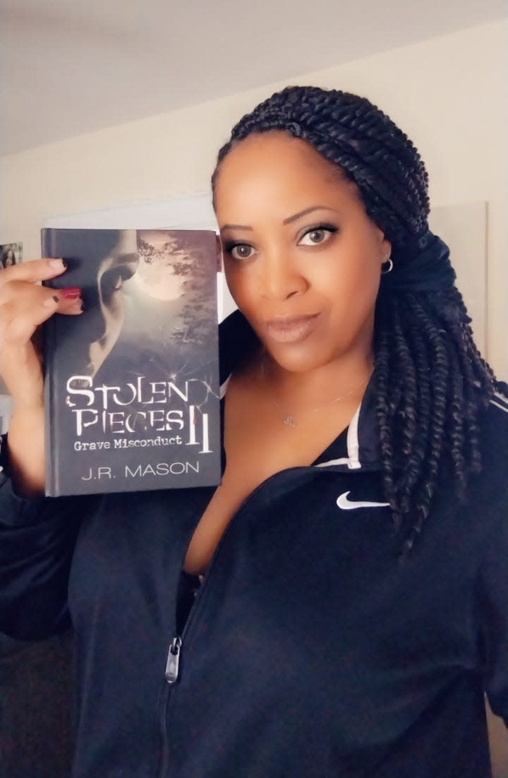 Ambridge author J.R. Mason holds her latest novel, "Stolen Pieces II: Grave Misconduct."