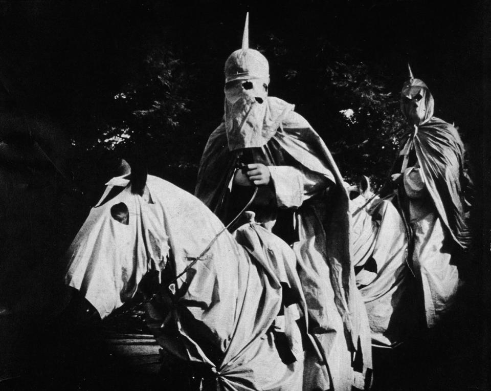 <p>Actors costumed in the full regalia of the Ku Klux Klan ride on horses at night in a still from ‘The Birth of a Nation,’ the first-ever feature-length film, directed by D. W. Griffith, 1914. (Photo: Hulton Archive/Getty Images) </p>