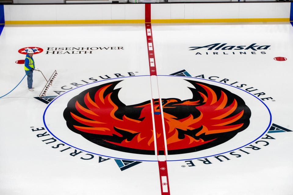 Mid American Rink Services workers spray water and thin layers of paint to make the ice and logos inside Acrisure Arena, the home of the Coachella Valley Firebirds, hockey rink in Thousand Palms, Calif., on Wednesday, Dec. 7, 2022. 