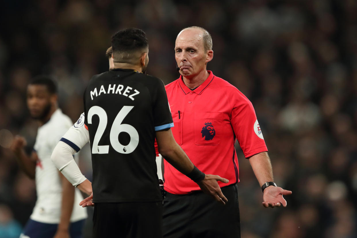 LONDON, ENGLAND - FEBRUARY 02: Match referee Mike Dean reacts to Riyad Mahrez of Manchester City during the Premier League match between Tottenham Hotspur and Manchester City at Tottenham Hotspur Stadium on February 2, 2020 in London, United Kingdom. (Photo by James Williamson - AMA/Getty Images)