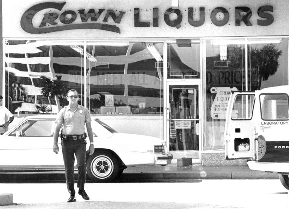 File photo from July 11, 1979, at Dadeland Mall. Police and crime lab technicians pore over Crown Liquors in the parking lot after gunmen armed with sub machine guns sprayed more than 60 rounds inside the store, killing a rival drug dealer and his bodyguard and wounding two bystander employees.