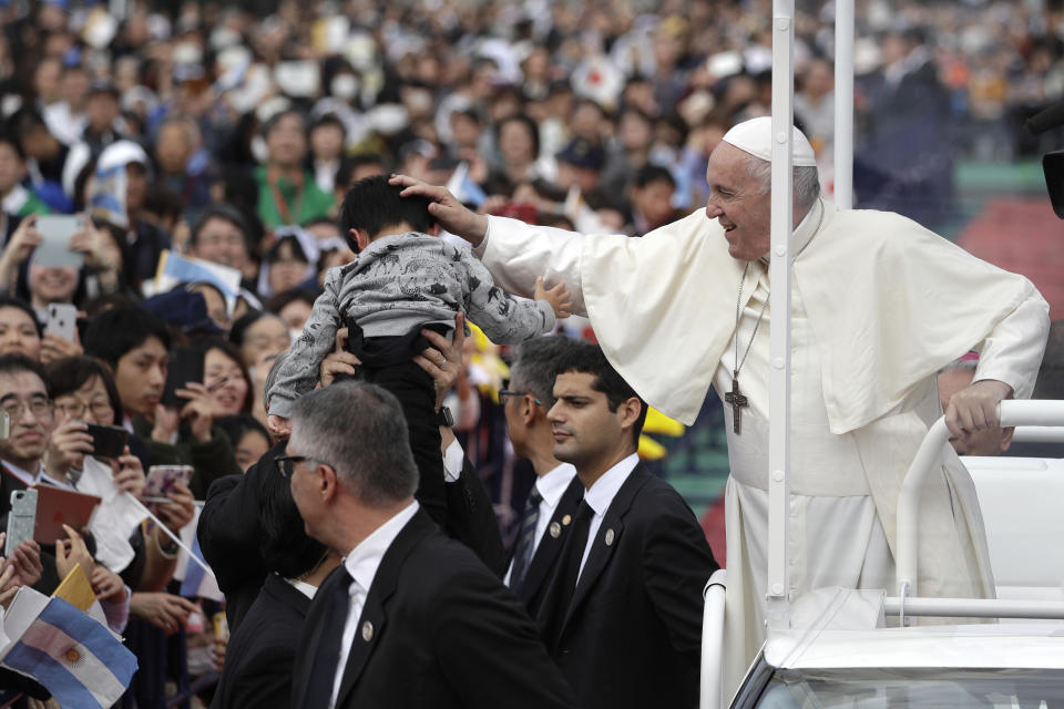 Pope Francis caresses a child as he arrives for a Mass at a baseball stadium Sunday, Nov. 24, 2019, in Nagasaki, Japan. (AP Photo/Gregorio Borgia)