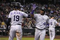 Colorado Rockies' Elehuris Montero celebrates with Charlie Blackmon (19) after hitting a solo home run against the Arizona Diamondbacks during the eighth inning during a baseball game Saturday, Aug. 6, 2022, in Phoenix. Colorado won 3-2. (AP Photo/Rick Scuteri)