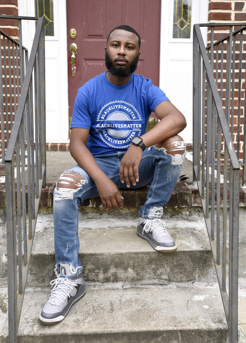 Ade Okupe sits outside his home in Parkville, Md., near Baltimore, on Saturday, Oct. 10, 2020. Okupe is among the many young Black immigrants or children of immigrants who say they are speaking out for racial equity while also trying to convince older members of their communities that these issues should matter to them, too. (AP Photo/Steve Ruark)