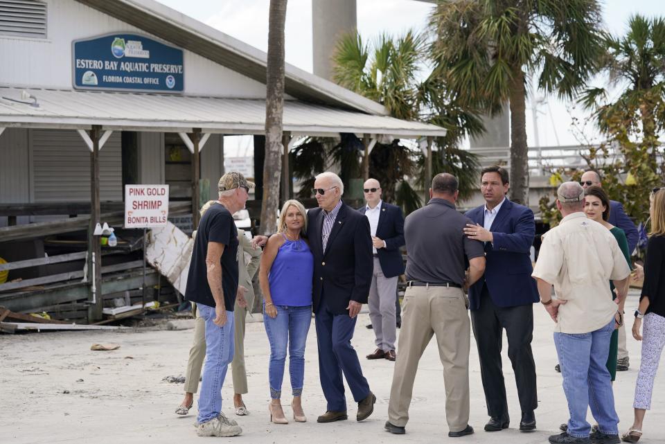 President Joe Biden and Florida Gov. Ron DeSantis talk to people impacted by Hurricane Ian during a tour of the area on Wednesday, Oct. 5, 2022, in Fort Myers Beach, Fla. (AP Photo/Evan Vucci)