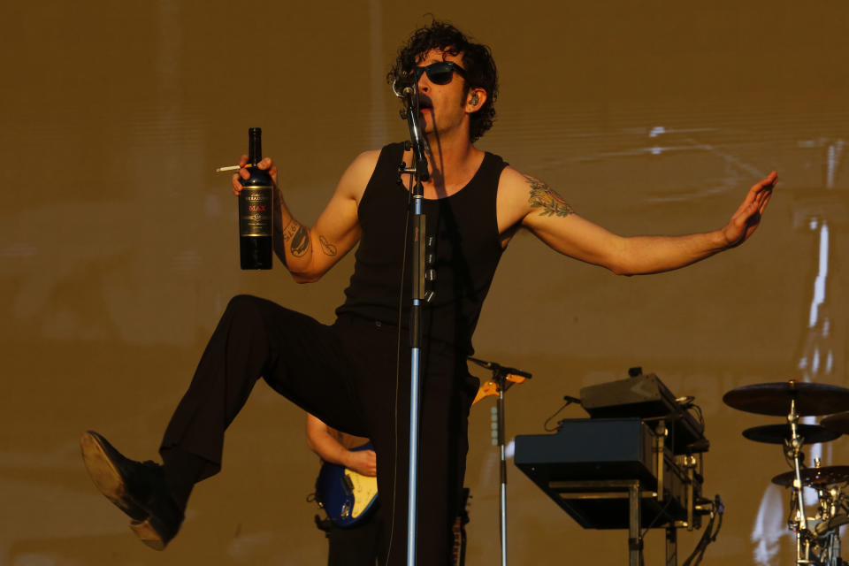Matty onstage with a bottle and a cigarette