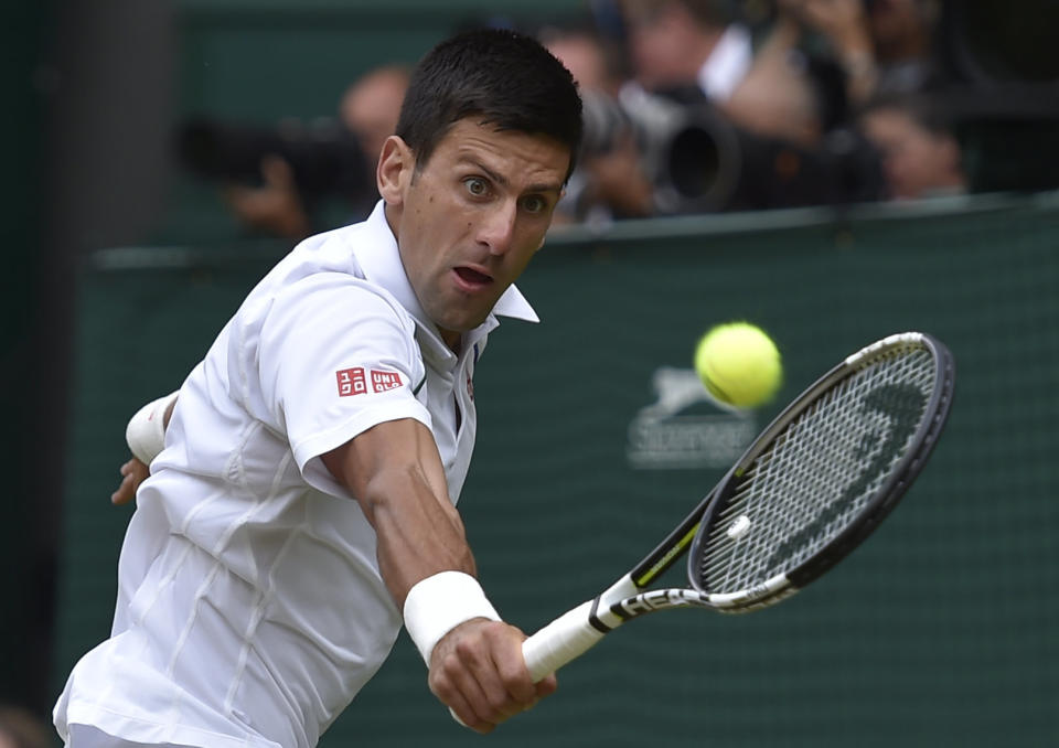 Novak Djokovic of Serbia plays a return to Roger Federer of Switzerland during the men's singles final at the All England Lawn Tennis Championships in Wimbledon, London, Sunday July 12, 2015. (Toby Melville/Pool Photo via AP)