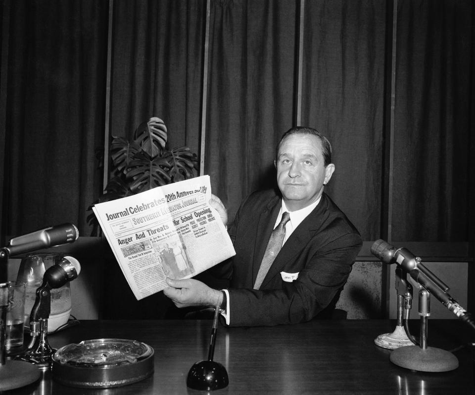 Arkansas Gov. Orval Faubus shows his television audience a local black newspaper headline: "Anger and Threats Mar School Opening" in Little Rock, Sept. 3, 1957.