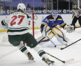 St. Louis Blues goaltender Ville Husso (35) stops a point blank shot from Minnesota Wild's Nick Bjugstad (27) in the first period of an NHL hockey game, Wednesday, May 12, 2021 in St. Louis. (AP Photo/Tom Gannam)