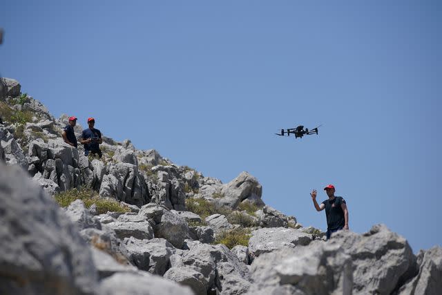 <p>Yui Mok/PA Images via Getty</p> A member of the search team flying a drone in Symi, Greece, where a search and rescue operation is under way for TV doctor and columnist Michael Mosley.