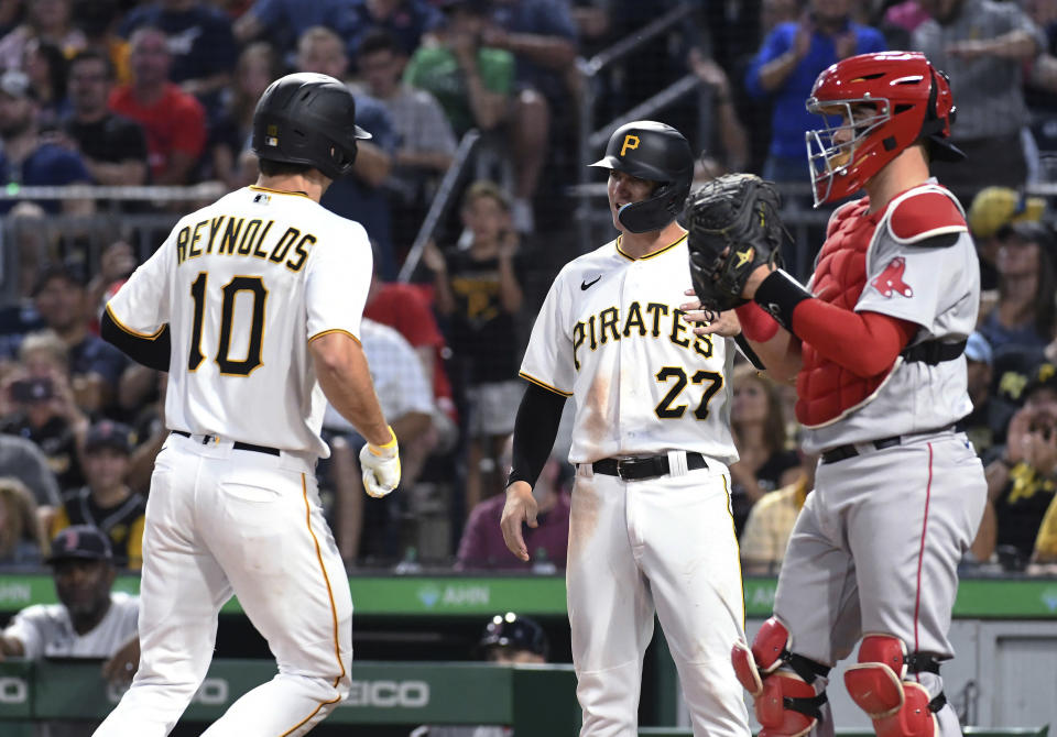 Pittsburgh Pirates batter Bryan Reynolds (10) is greeted by Kevin Newman (27) after Reynolds' two-run home run, next to Boston Red Sox catcher Reese McGuire during the fifth inning of a baseball game Thursday, Aug. 18, 2022, in Pittsburgh. (AP Photo/Philip G. Pavely)