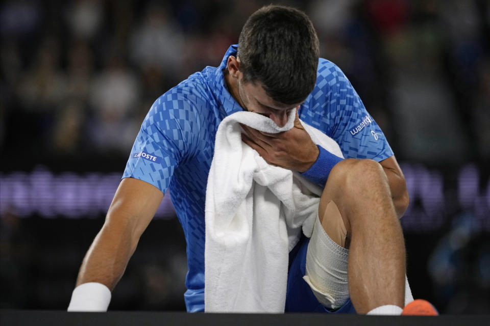 Novak Djokovic of Serbia reacts as he stretches his legs during his second round match against Enzo Couacaud of France at the Australian Open tennis championship in Melbourne, Australia, Thursday, Jan. 19, 2023. (AP Photo/Aaron Favila)