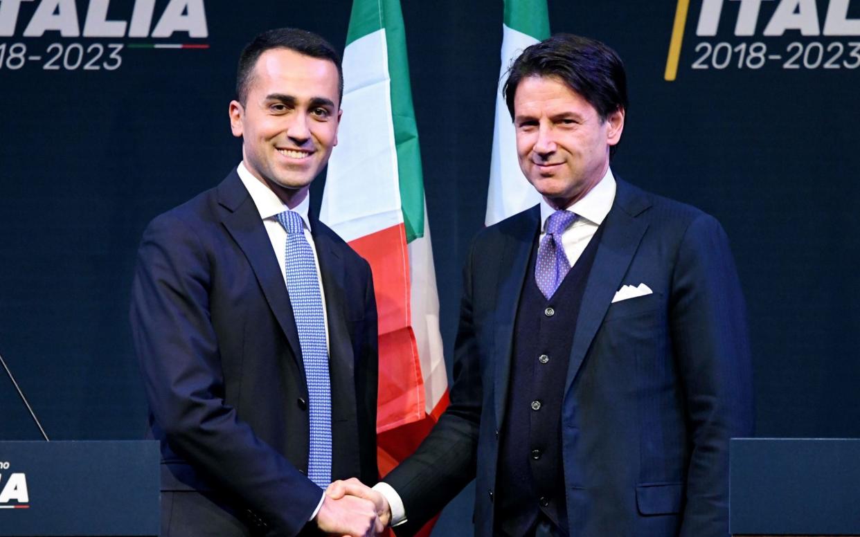 In a file photo from March 2018, Luigi Di Maio (L) shakes hands with law professor Giuseppe Conte, now nominated to be prime minister - AFP