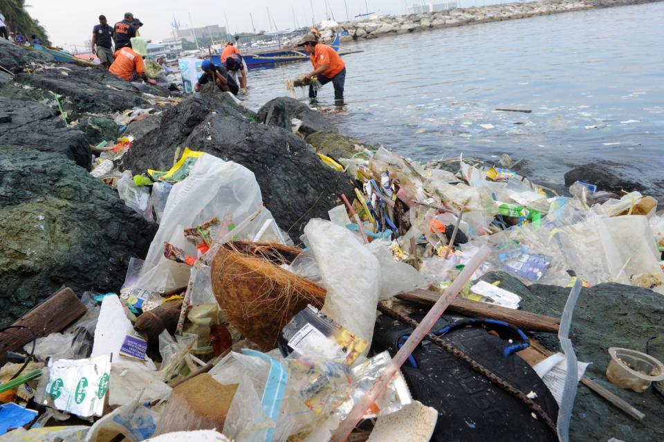 <p>People collect plastic bags and other types of garbage&nbsp;from the Manila Bay on July 3, 2014.</p>