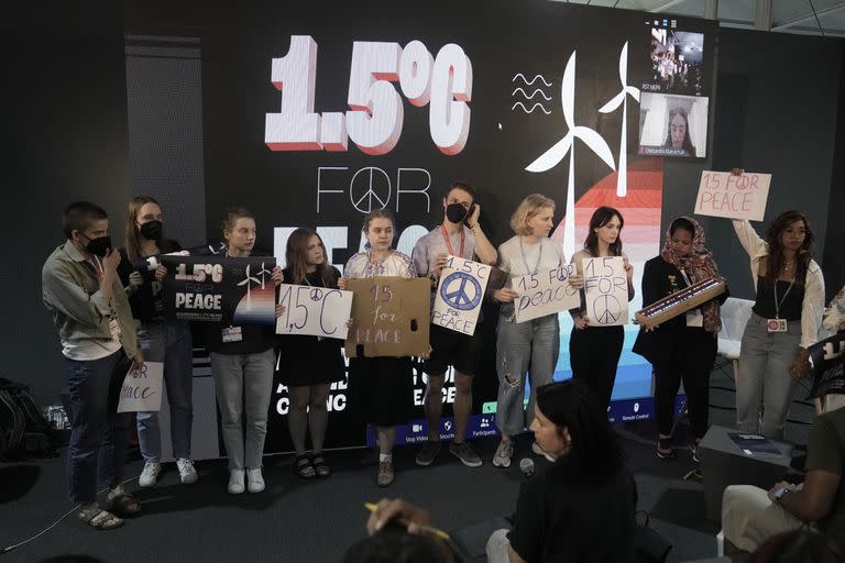 Activistas sostienen carteles con el lema 1,5 grados (Celsius) para la paz durante una sesión de la cumbre climática de Naciones Unidas, el 17 de noviembre de 2022, in Sharm el-Sheij, Egipto. (AP Foto/Nariman El-Mofty)