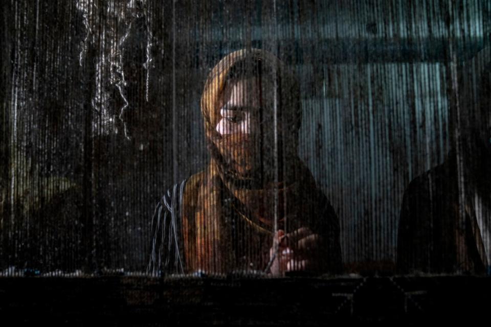 An Afghan woman weaves a carpet at a traditional carpet factory in Kabul, Afghanistan where women have seen their freedom increasingly restricted since Taliban came into power (AP)