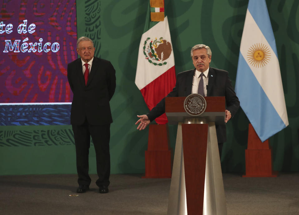 Argentina's President Alberto Fernández speaks during Mexican President Andrés Manuel López Obrador's daily, morning press conference, as Lopez Obrador stands behind at the National Palace in Mexico City, Tuesday, Feb. 23, 2021. Fernández is on a four-day official visit to Mexico. (AP Photo/Marco Ugarte)