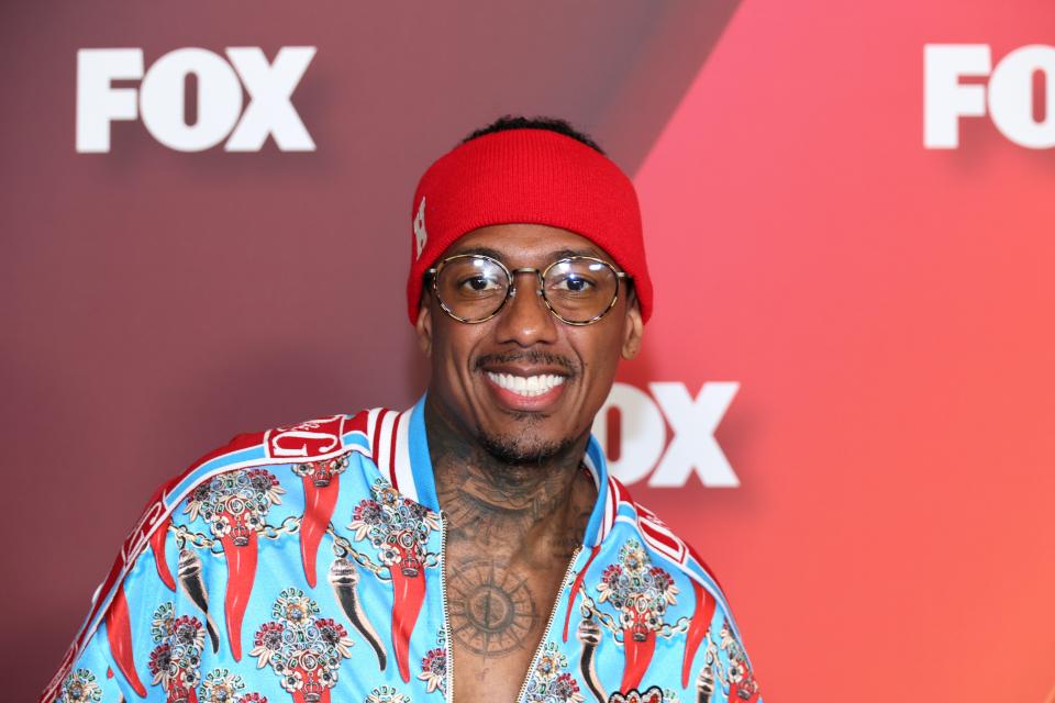 Nick Cannon wearing a patterned blue shirt and a bright red headband at the Fox Upfront in New York City.