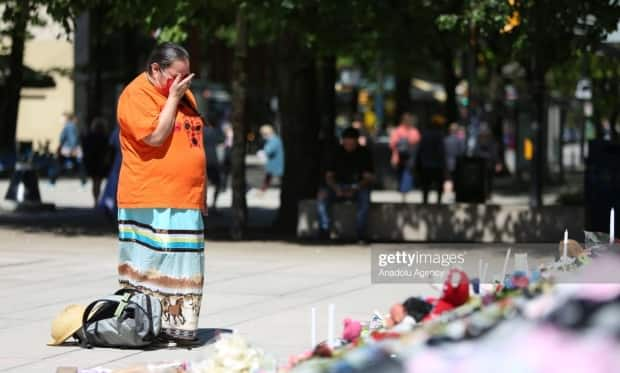 A photograph of Loretta John mourning residential school victims at a memorial in Vancouver is being licensed by Getty Images for up to $575. John, who gave CBC permission to use the image, says she wants any profits to be given to residential school survivors and support groups. (Mert Alper Dervis/Getty Images - image credit)