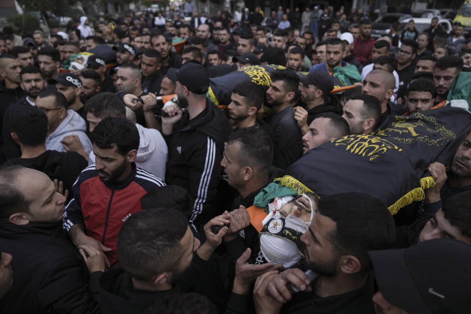 Mourners carry the bodies of three Palestinian militants, draped in the flag of the Islamic Jihad militant group, during their funeral in the West Bank city of Jenin, Thursday, March 9, 2023. Palestinian officials say at least three Palestinian militants were killed after Israeli security forces entered a village in the northern occupied West Bank. The Israeli Police said Thursday that troops carried out a raid in Jaba to apprehend suspects wanted for attacks on Israeli soldiers in the vicinity. The three militants killed included the head of a local Palestinian militant group. (AP Photo/Nasser Nasser)