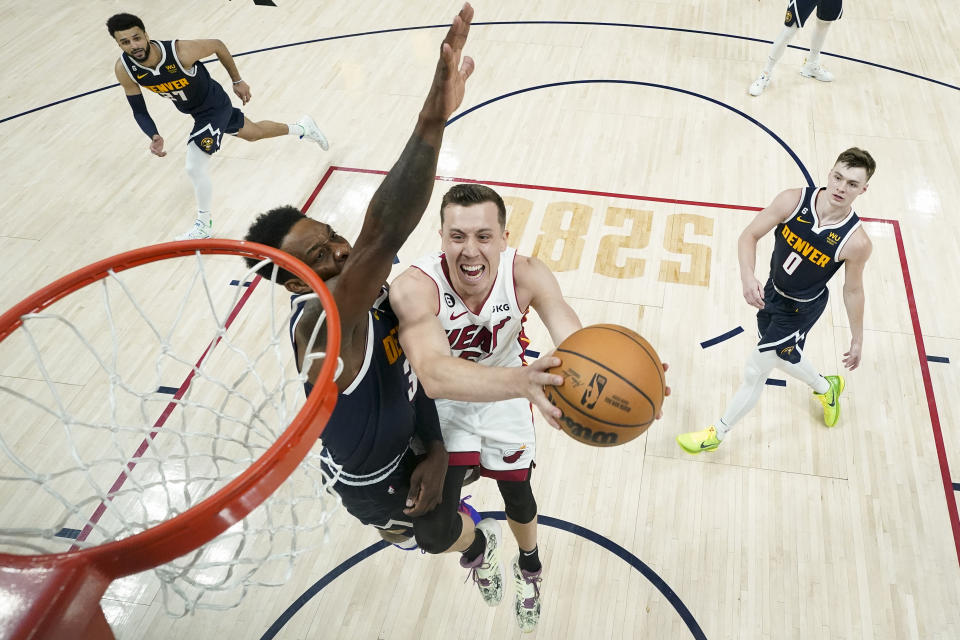 Miami Heat forward Duncan Robinson, center, shoots the ball while defended by Denver Nuggets forward Jeff Green, left, during the second half of Game 2 of basketball's NBA Finals, Sunday, June 4, 2023, in Denver. (AP Photo/Mark J. Terrill, Pool)