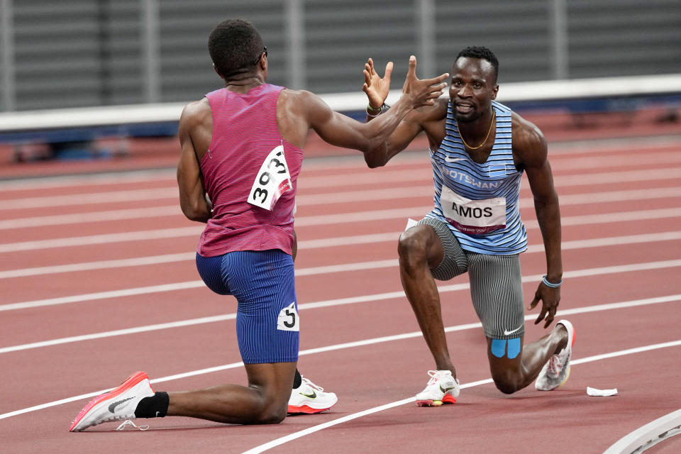 Isaiah Jewett, of the United States, and Nijel Amos, right, of Botswana, shake hands after falling in the men's 800-meter semifinal at the 2020 Summer Olympics, Sunday, Aug. 1, 2021, in Tokyo. (AP Photo/Jae C. Hong)