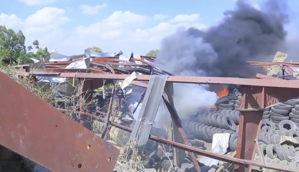 In this image made from video, a car factory burns in Mekele, Ethiopia, Wednesday, Oct. 20, 2021. Residents say new airstrikes have hit the capital of Ethiopia’s Tigray region as exclusive video shows injured people with bloodied faces being carried into ambulances. Ethiopia's government says it targeted facilities for making and repairing weapons, while a Tigray spokesman denies it. (AP Photo)